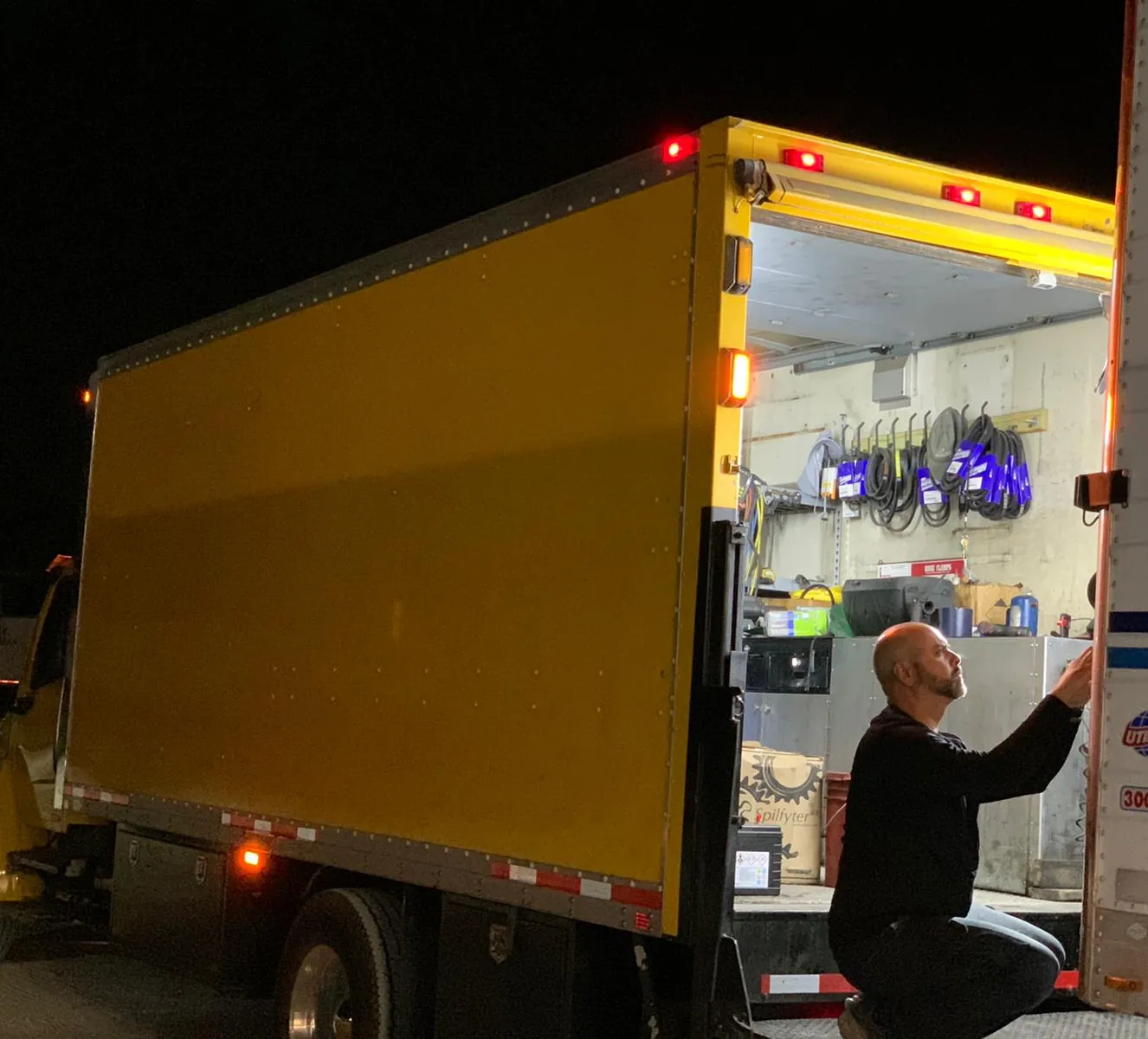 Technician on an after-hours emergency reefer repair at night