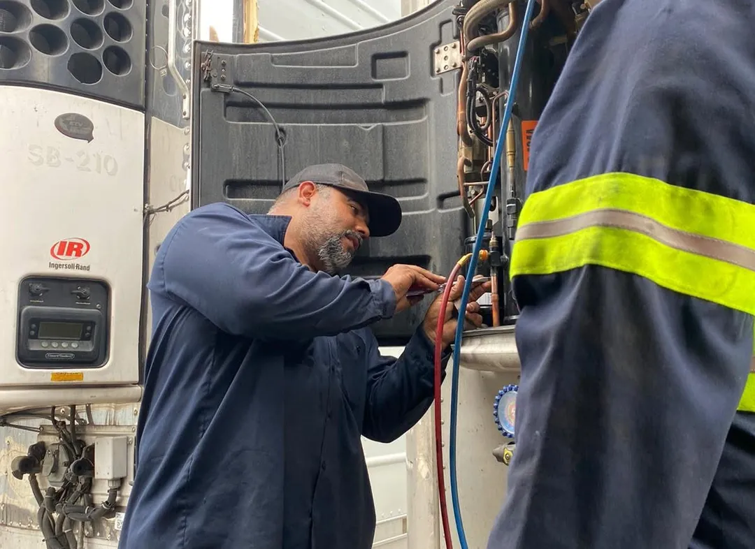 Technician performing preventative maintenance on a reefer unit