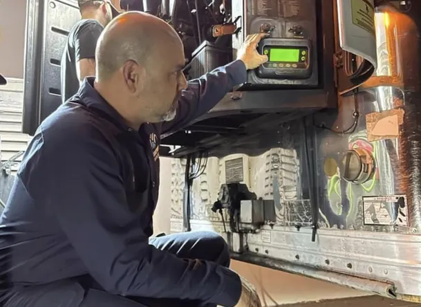 Technician repairing a reefer unit control panel