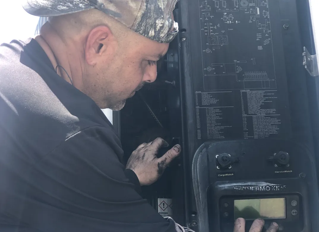 Technician checking a reefer unit controller during preventative maintenance