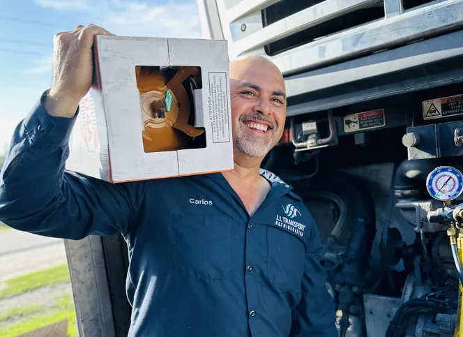 Technician carrying a reefer replacement part